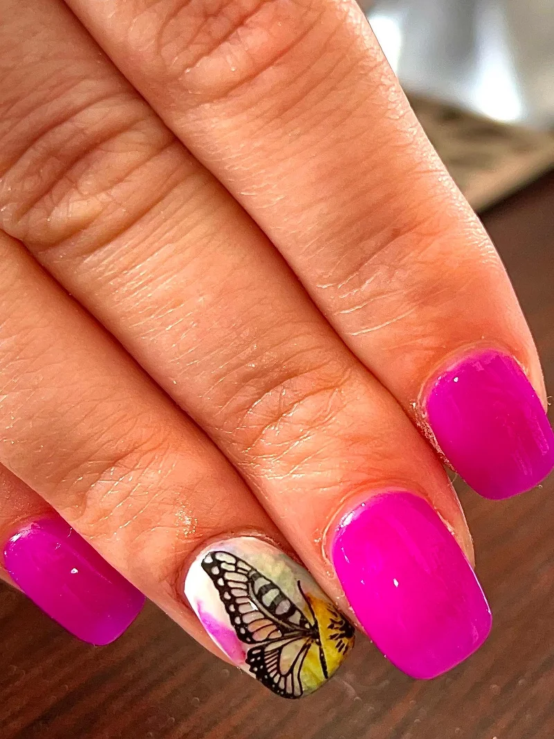 Magenta nails with butterfly accent