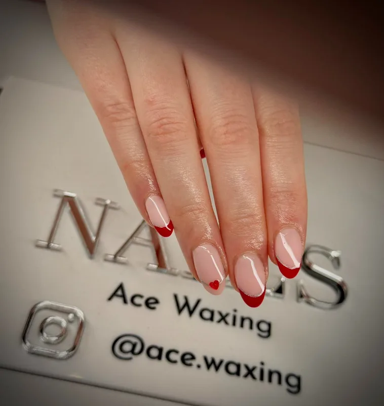 Red French tip nails with heart accent
