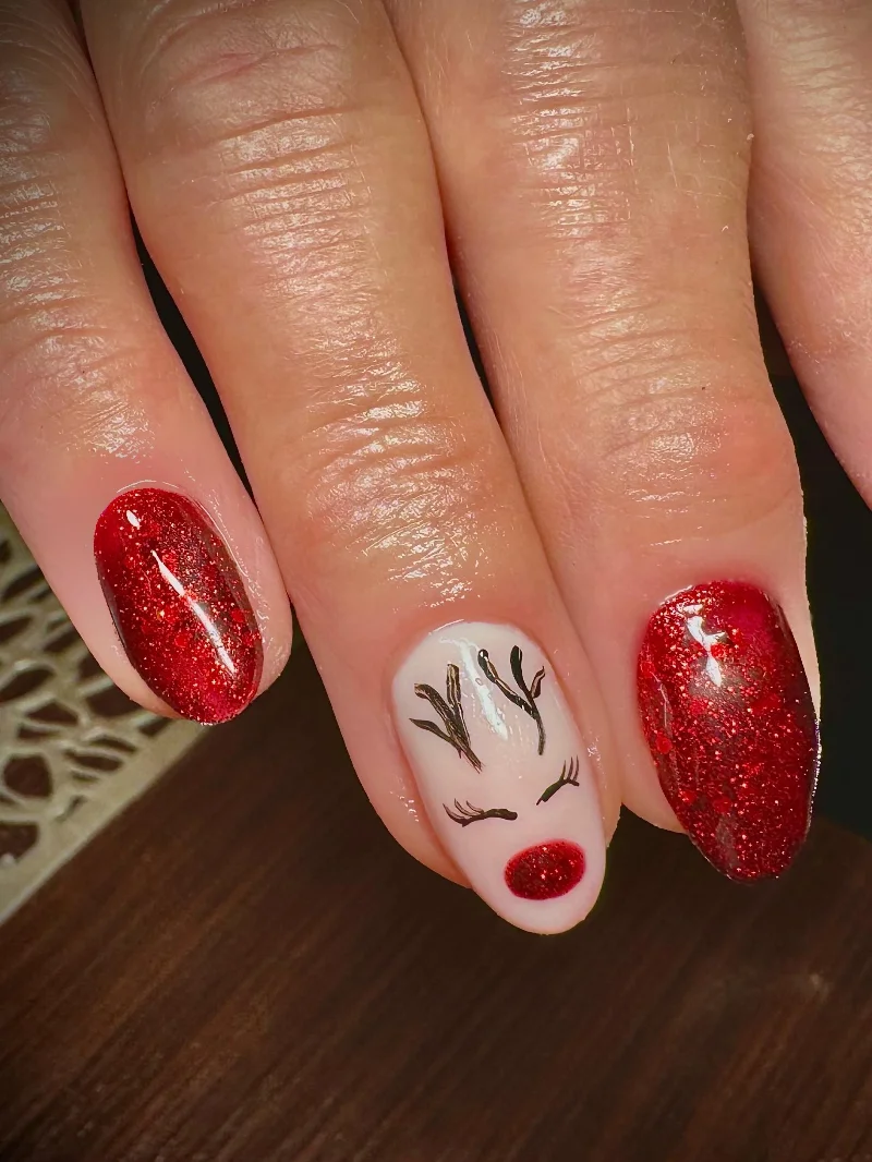 Red glitter nails with reindeer Christmas design